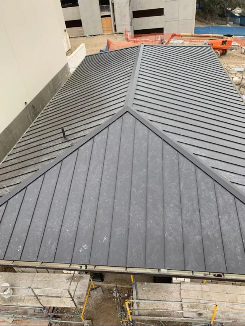 Commercial metal roof construction with crane equipment in Warminster